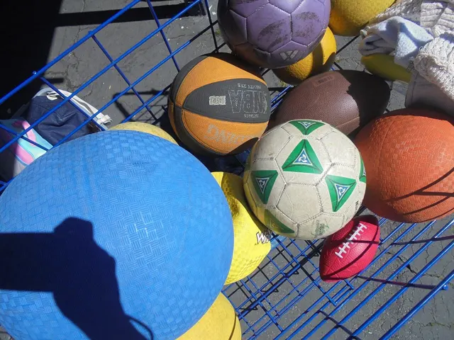 Sports balls of different sizes in a ball cart