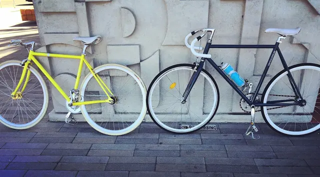 Two bicycles parked against a wall